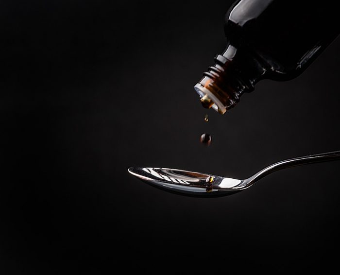 Drop of syrup falling into a spoon