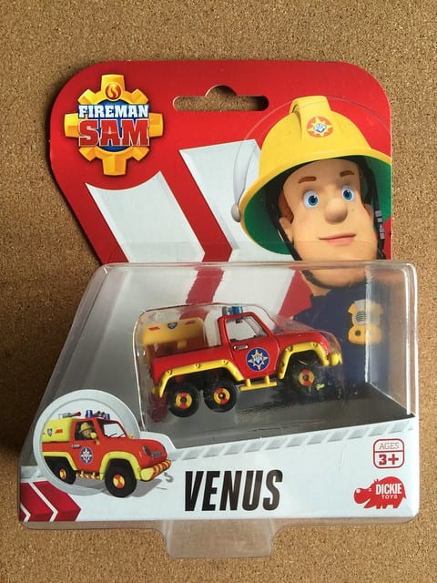 Fireman Sam: Packaged 'Fireman Sam' Venus fire truck toy, with an illustration of Fireman Sam on the red and yellow packaging.