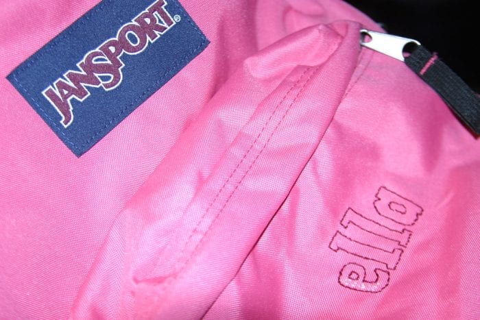 Close-up of a pink Jansport backpack with embroidered text, potentially customized for a medical student's personal use.