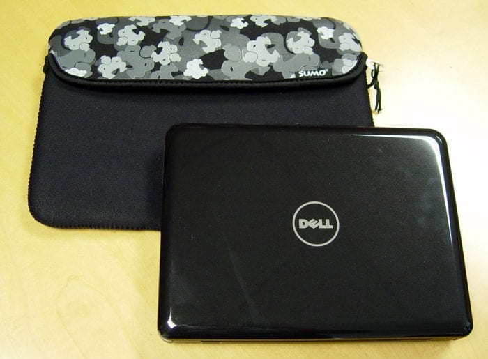 A black Dell laptop beside a camo-patterned Sumo laptop sleeve, accessories that could be part of a medical student's tech gear and backpack.