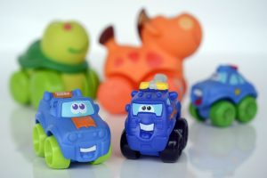 There are three blue cars with different design. There is also a blurry figure of a horse and a turtle at the back of the the cars.