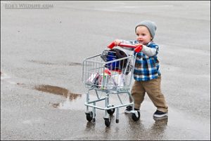 little child excited to have fun and push the trolley in the parking lot