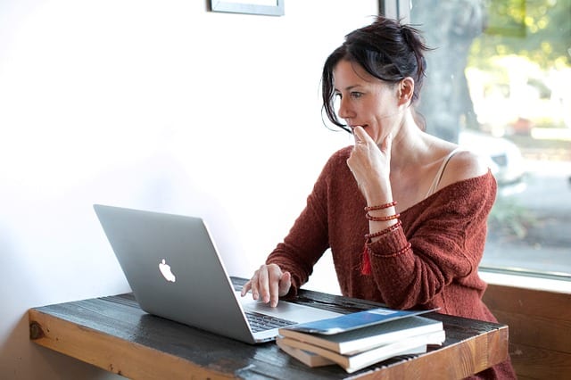 A woman finding gown boutiques in her laptop.