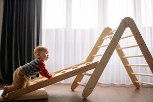 A young boy is trying his very best to climb and play with the toddler climbing toys. This kind of climbing activity can help young ones to improve and develop muscle strength. This is a good toy alternative for robots as well. They can practice their climbing ability just inside your home. 