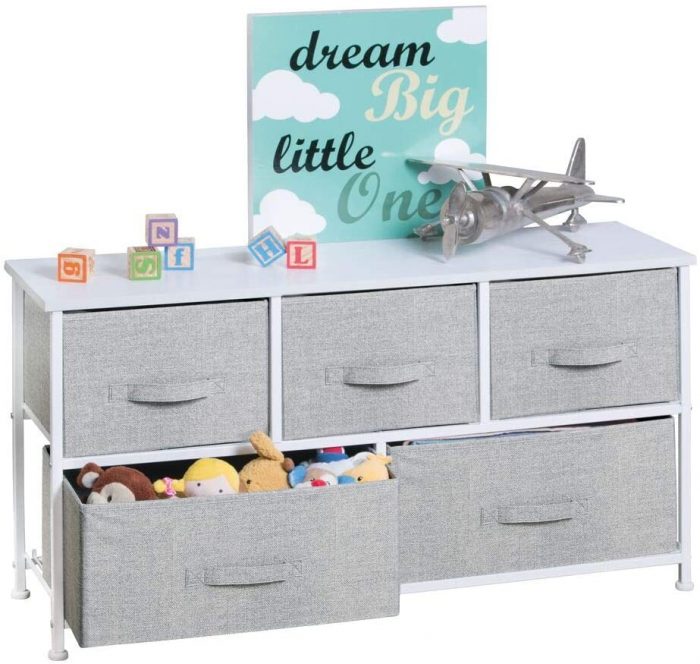 A baby dresser with toys on the top. 
