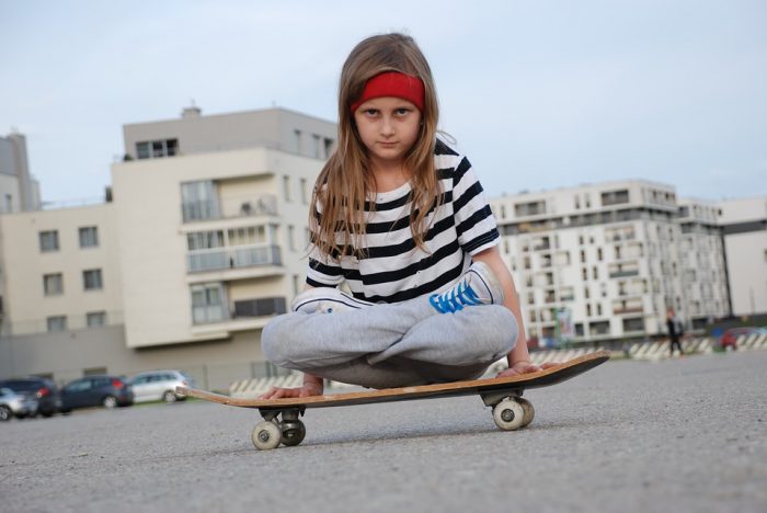 Girl kid riding a skateboard. Skateboard teaches kids proper coordination. 