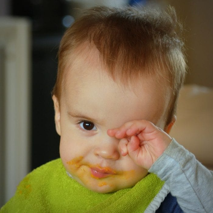 baby looks sleepy. he may want to sleep. This baby is scratching his eyes. He may wants to sleep.