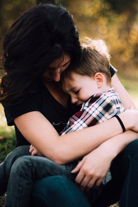 mother happily cuddling and holding her 22-month-old baby in her arms