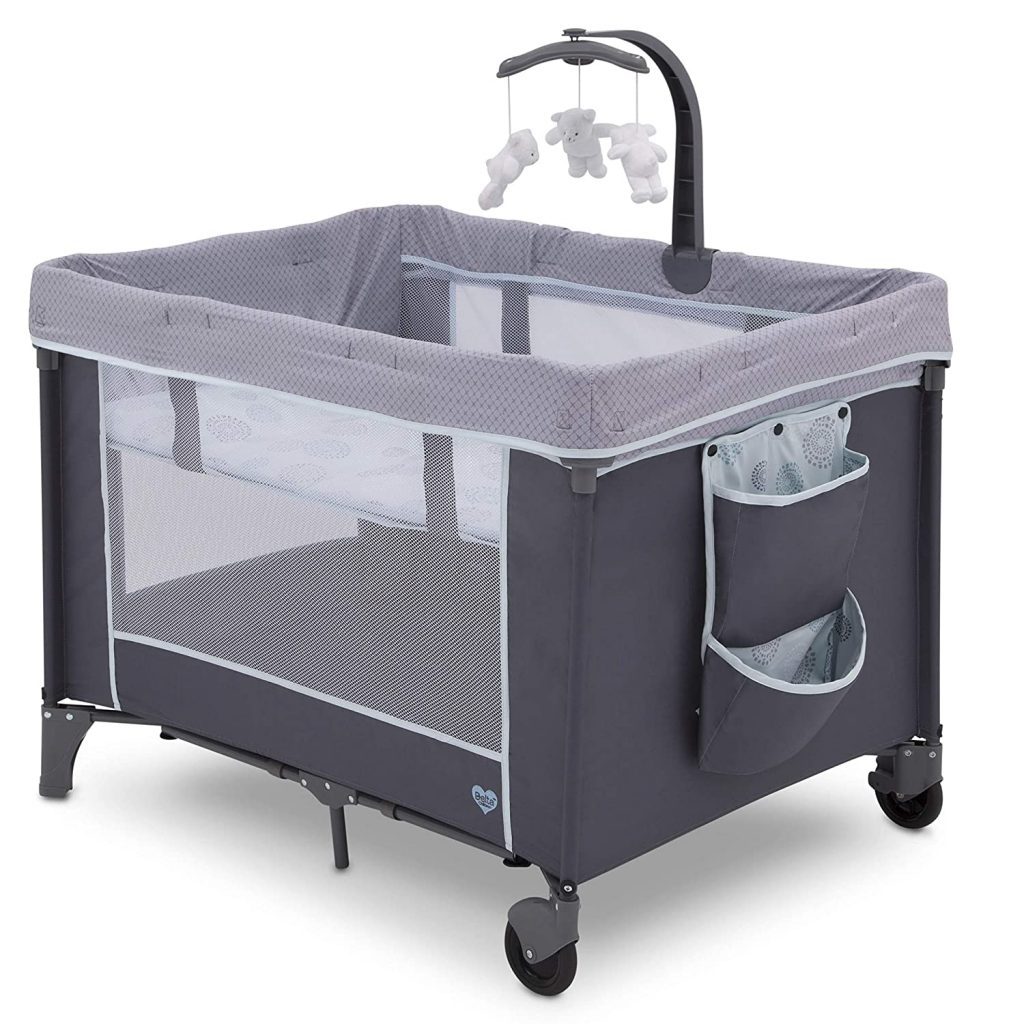 A mini gray pack n play portable crib. This pack n play has a mobile on the side.