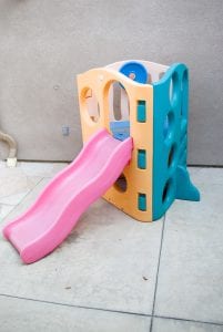 A pink Little Tikes playset with a slide and climbing frame. The slide is about 6 feet long and 3 feet wide. The climbing frame is about 6 feet tall and 3 feet wide. It has a ladder, a platform, and a small crawl-through tunnel.