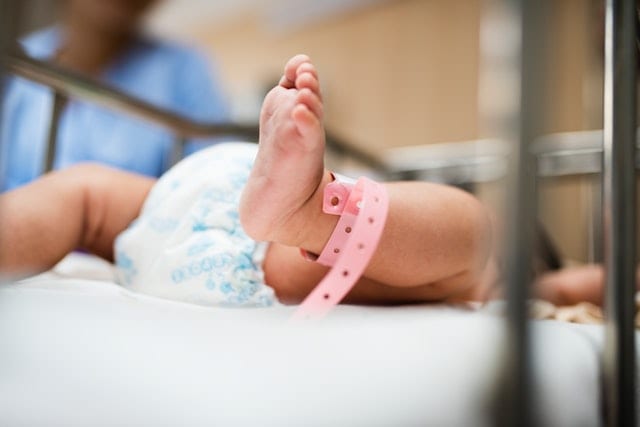 A baby laying while wearing a nappy