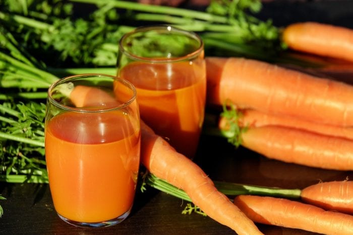 A healthy carrot juice and raw carrots