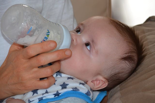 A parent feeding their child or a mom night feeding her baby