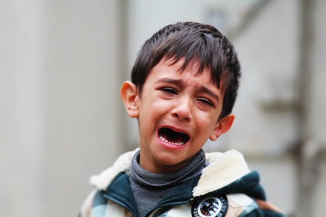 A little child cries while looking for his mom. A common behavior of a needy kiddo.