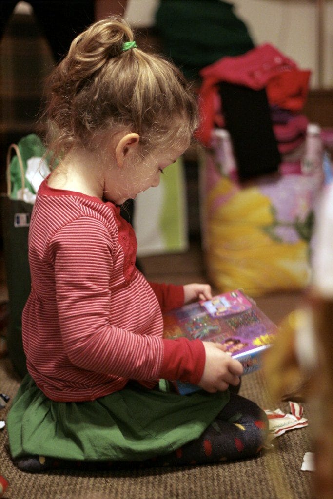 A little kid looking at her toy