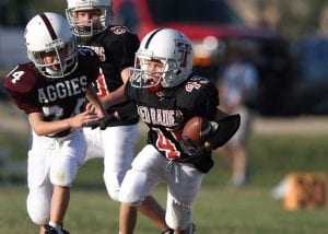 A youth with youth football helmets. 