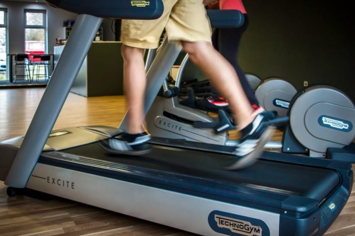 Man running on a TechnoGym treadmill. Check out the best treadmills under $300 for house gym set up.
