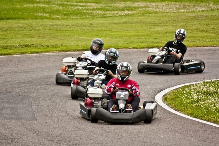 teens and kids riding a go-kart. 