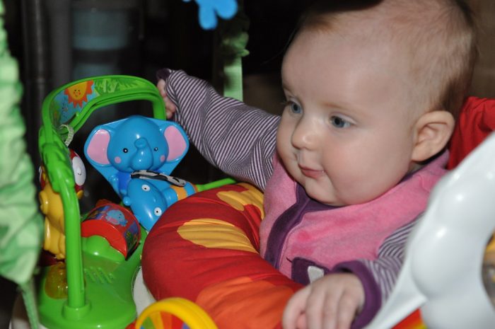 blue eyes baby playing with baby jumper - the best way to entertain and develop gross motor skills!