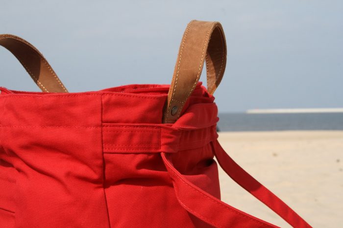 A red beach bag for moms is elegant and stylish bag for the beach. 