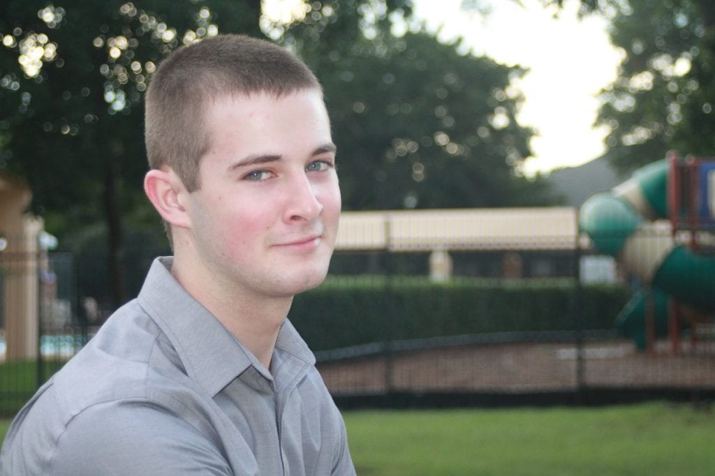 Smiling male teenager in his stylish gray polo shirt, radiating positivity and confidence for a purpose. Casual and comfortable fashion for vibrant look.