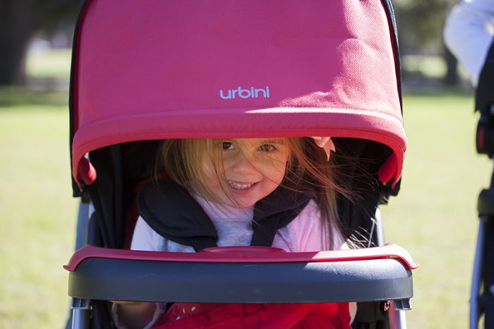 A kid riding a stroller