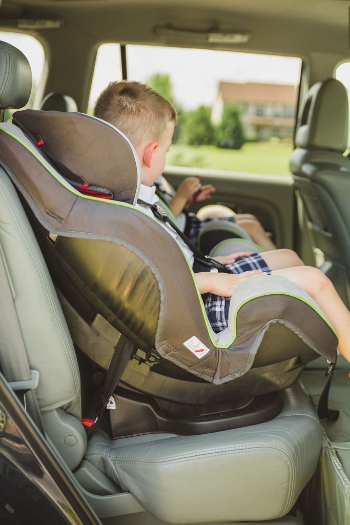 There are two boys in car seats.