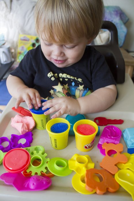 A child enjoying Play Doh sets and engaging in creative play.