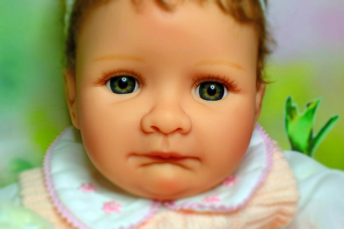 A doll that has realistic features and lifelike expressions. It looks like it will cry. 