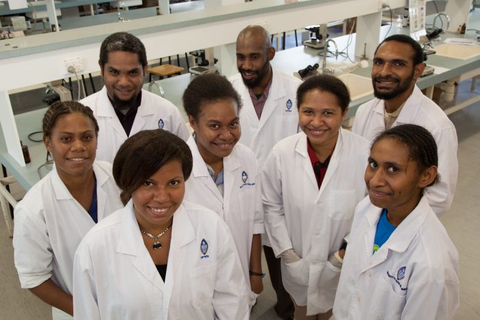 Future physicians are beaming toward the camera. The sense of unity is palpable from their matching attire - pristine and professional white coats, for symbolizing their shared journey through the demanding world of medical education.