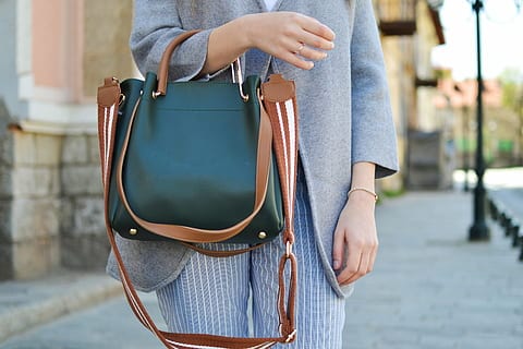 Woman carrying one of the best designer handbags for style and functionality on a city street.