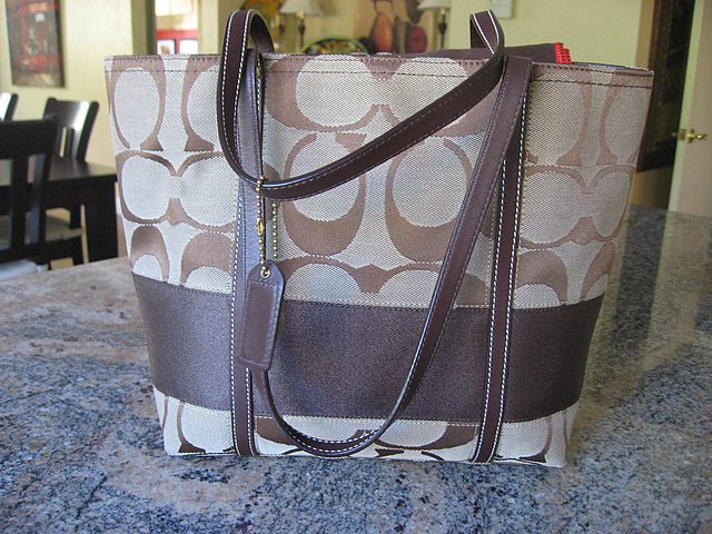 Best designer tote bag with a signature print and leather straps on a kitchen counter.