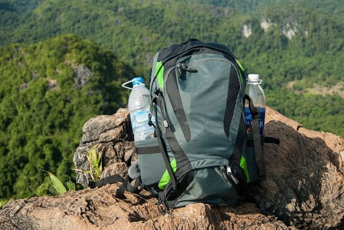 A green backpack with two bottles of water