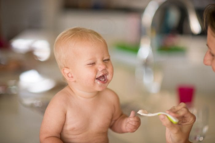 Baby happily eating yogurt