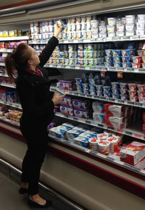 A woman shops for the best yogurt for her baby in the supermarket.