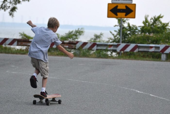 A kid learning how to use a skateboard