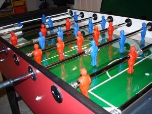 Best quality foosball table with red and blue figures ready for a football match.