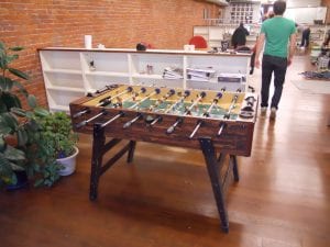 A vintage-style foosball table set in a spacious room, ready for the best football game.