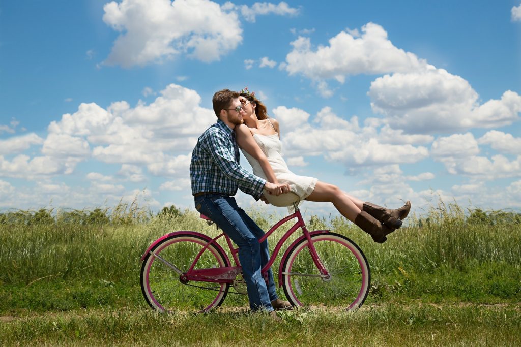 a couple using a pink bicycle