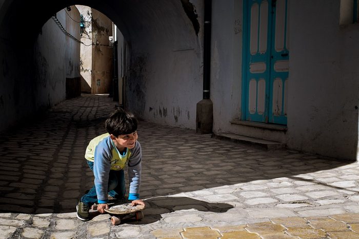 little kid using a skateboard while happy