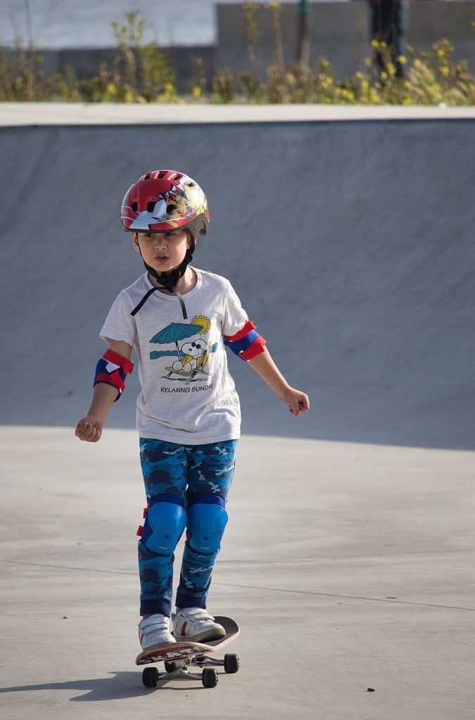 a 6 year old boy riding his skateboard