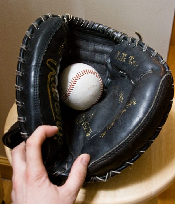 A close-up photo of catchers mitt with a baseball in the middle of it.