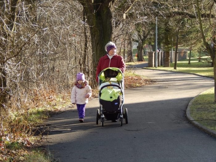 Woman and a child walking with a stroller.