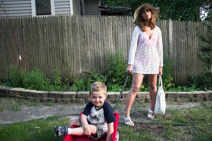 A mother holding her trendy tote while playing with her toddler.