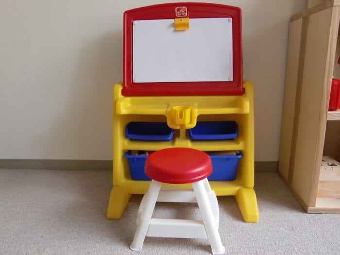 One best simple and colorful toddler's easel placed in the side of a brightly-lit room. This easel makes writing, drawing, and painting easier. 