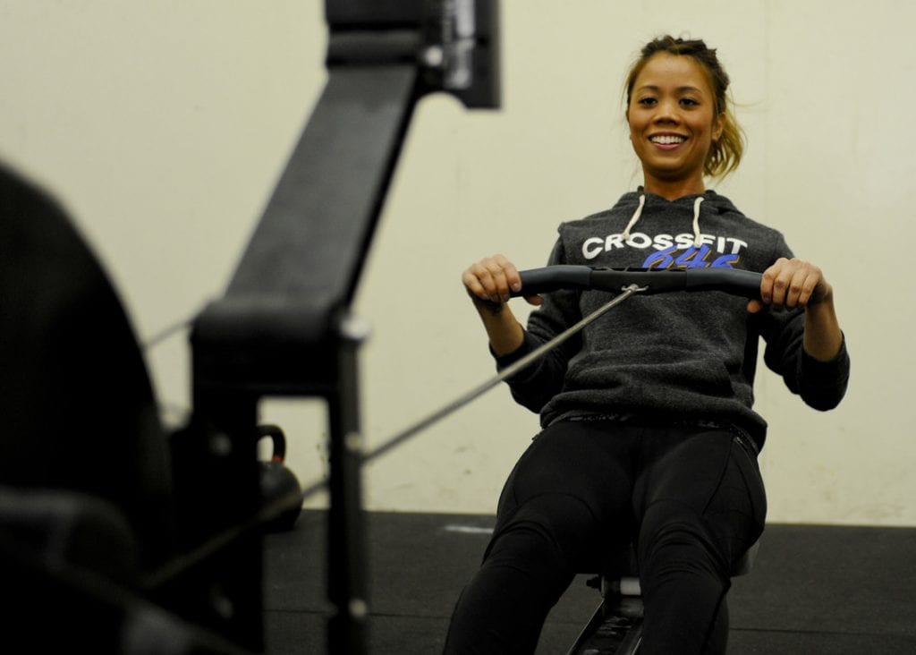 A woman with brown hair wearing a black hoodie is trying the rowing equipment under 200. Read, learn and understand more information before buying. This is to give readers the information they need before making a choice to buy.