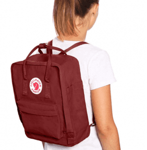 Backpack: Woman wearing a red backpack, suitable for nursing essentials, with a circular logo on the front pocket.