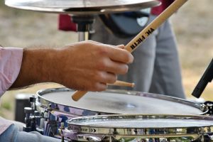 A person's hands holding drum sticks, considered among the best drumsticks for beginners.