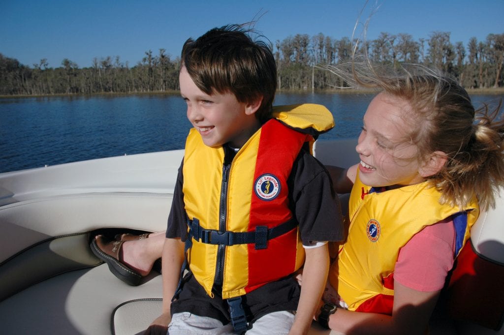 Two kids wearing the best jet ski life jacket. Wearing a ski vest while water skiing is essential to your safety.