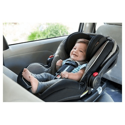 The baby smiles and sits comfortably while using his Graco LX car seat. 